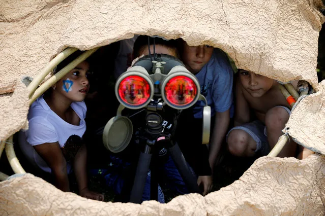 Israeli children look through binoculars during a display of Israeli Defense Forces equipment and abilities, as part of the celebrations for Israel's Independence Day marking the 69th anniversary, in the southern city of Sderot, Israel May 2, 2017. (Photo by Amir Cohen/Reuters)