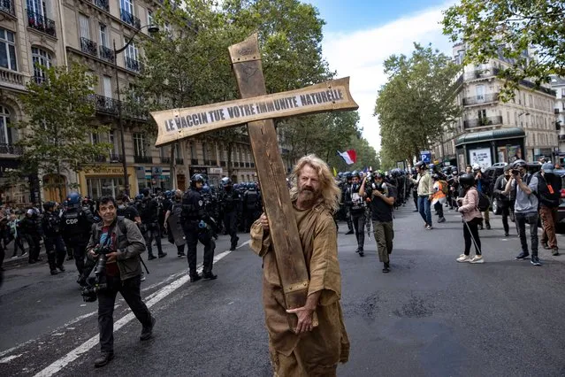 A protester dressed as Jesus holds a cross bearing the message “the vaccine kills your immune system”, during a demonstration against the COVID-19 health pass which grants vaccinated individuals greater ease of access to venues in France, in Paris, France, 07 August 2021. The national enforcement of the “Health Pass” is expected to take effect on 09 August, after the French Constitutional Council has confirmed the government's law which extend the use of its Vaccinal Passeport (a QR code which proves the bearer has received full vaccination, or been tested negative for Covid in the last 72 hours) to cultural place, transport, and restaurants among other places. (Photo by Ian Langsdon/EPA/EFE)