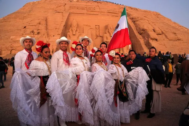 Men and women dressed in traditional Mexican dress pose with a Mexican flag as visitors gather outside Ramses II's (1279-1213 BC) Great Temple in Egypt's southern town of Abu Simbel during the solar alignment early on February 22, 2022. (Photo by Mohamed Asad/AFP Photo)