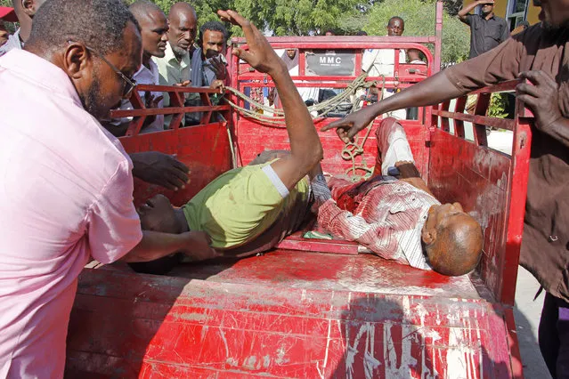 Civilians who were wounded in suicide car bomb attack are helped at check point in Mogadishu, Somalia, Saturday, December 28, 2019. A police officer says a car bomb has detonated at a security checkpoint during the morning rush hour in Somalia's capital. (Photo by Farah Abdi Warsame/AP Photo)