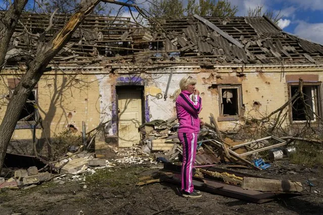 Iryna Martsyniuk, 50, stands next to her house, heavily damaged after a Russian bombing in Velyka Kostromka village, Ukraine, Thursday, May 19, 2022. Martsyniuk and her three young children were at home when the attack occurred in the village, a few kilometres from the front lines, but they all survived unharmed. (Photo by Francisco Seco/AP Photo)