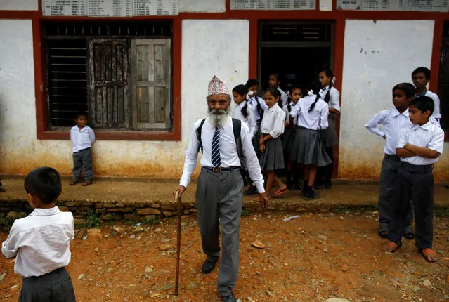 Durga Kami, 68, who is studying in the tenth grade at Shree Kala Bhairab Higher Secondary School, walks outside the school in Syangja, Nepal, June 5, 2016. (Photo by Navesh Chitrakar/Reuters)