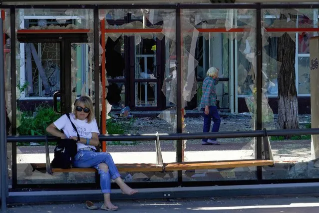 A woman sits at a destroyed bus station in the city of Mariupol on June 4, 2022, amid the ongoing Russian military action in Ukraine. (Photo by AFP Photo/Stringer)