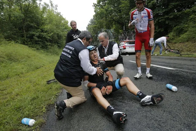 Medics tend to Spain's Xabier Zandio after he crashed during the sixth stage of the Tour de France cycling race over 194 kilometers (120.5 miles) with start in Arras and finish in Reims, France, Thursday, July 10, 2014. Zandio is the second team Sky rider to abandon the race after Britain's Christopher Froome crashed and abandoned yesterday. (Photo by Christophe Ena/AP Photo)