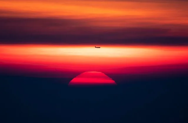 The sun rises through the thick fog over Frankfurt, Germany, as an aircraft passes by on Monday, November 25, 2019. (Photo by Michael Probst/AP Photo)