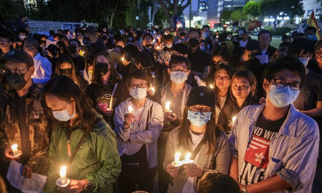 People attend a candlelight vigil outside the Chinese Consulate General in Los Angeles on Saturday, June 4, 2022, to mark the 33rd anniversary of the crackdown on the pro-democracy protests in Beijing's Tiananmen Square. (Photo by Ringo H.W. Chiu/AP Photo)