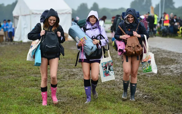 Let the fun begin. Revellers carry their belongings as they arrive at Worthy Farm in Somerset for the Glastonbury Festival, Britain, June 22, 2016. Around 180,000 are expected to attend. (Photo by Ben Birchall/PA Wire)