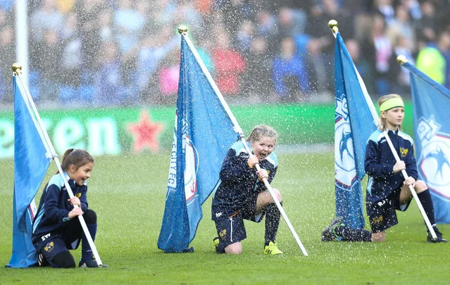 Young flag bearers get soaked by the ground’s sprinkler system before the start of the match Cardiff City v Swansea City in Cardiff, Wales on January 12, 2020. (Photo by Gareth Everett/Huw Evans/Rex Features/Shutterstock)