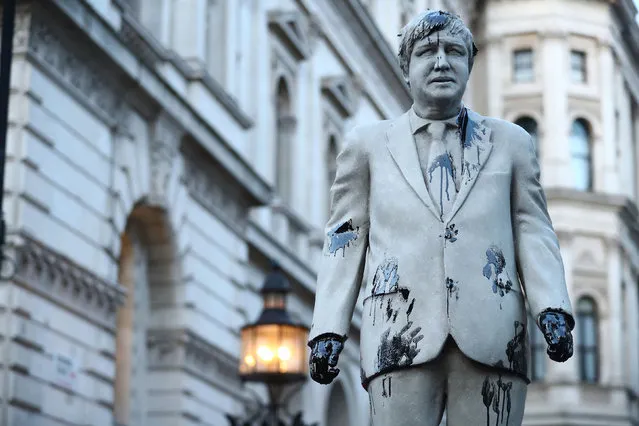 A statue depicting Britain’s Prime Minister Boris Johnson is seen stained with oil thrown by Greenpeace climate activists during a protest outside Downing Street, in London , Britain, October 11, 2021. (Photo by Hannah McKay/Reuters)