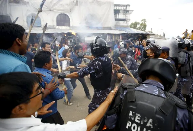 Protesters clash with police trying to stop them from marching during a rally organised by the 30-party alliance led by a hardline faction of former Maoist rebels, who are protesting against the draft of the new constitution, in Kathmandu August 15, 2015. (Photo by Navesh Chitrakar/Reuters)