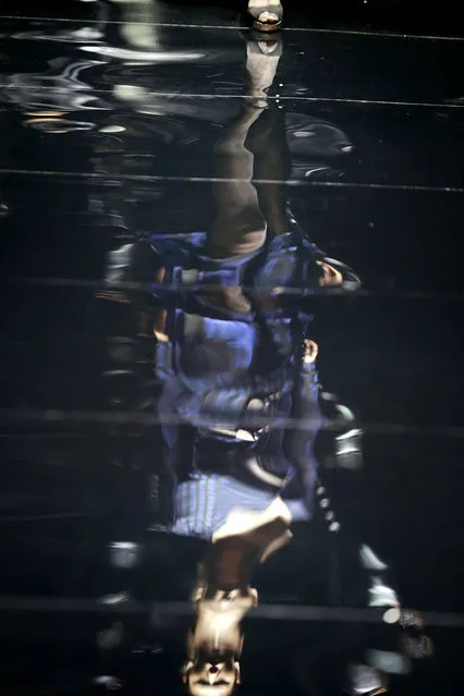 A shiny surface of a runway reflects a model showcasing an outfit from the collection “Seduction” by fashion designer Diane von Furstenberg, Wednesday, May 13, 2015, in Singapore during the opening show of the Singapore Fashion Week. (Photo by Wong Maye-E/AP Photo)