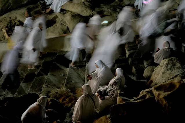 Muslim pilgrims pray on the rocky hill known as the Mountain of Mercy, on the Plain of Arafat, during the annual hajj pilgrimage, near the holy city of Mecca, Saudi Arabia, Friday, July 8, 2022. (Photo by Amr Nabil/AP Photo)