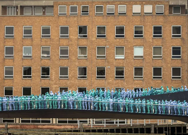 People stand on the Scale Lane Swing Bridge taking part in a mass nude art installation entitled Sea of Hull by New York based artist Spencer Tunick in Hull, England, Saturday July 9, 2016. Thousands of people stripped nude and are painted various shades of blue to participate in a huge installation at various locations in the sea side city on England's east coast, celebrating the city's maritime heritage. (Photo by Danny Lawson/PA Wire via AP Photo) 