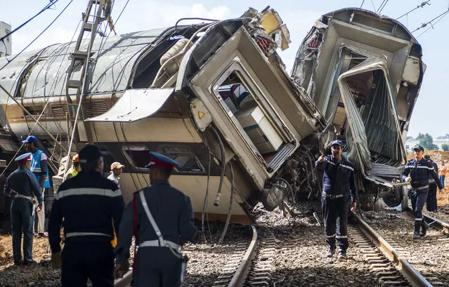 Members of the Moroccan civil defence and gendarmerie are seen at the scene of a rail accident in the town of Bouknadel, between the capital Rabat and the port city of Kenitra to its north, on October 16, 2018.  (Photo by Fadel Senna/AFP Photo)