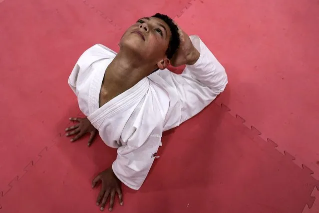 A karate student practices yoga at a dojo on the occasion of International Yoga Day in the Palestinian city of Ramallah in the occupied West Bank on June 21, 2022.  (Photo by Abbas Momani/AFP Photo)