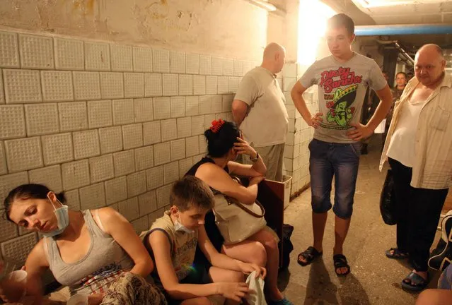 People sit in the basement of the city hospital in  Donetsk, eastern Ukraine, 07 August 2014. The death toll mounted on 06 August as Ukrainian and separatist forces fought for control of several eastern cities, with Western powers expressing concern about the possibility of a Russian incursion. Government airstrikes on central Donetsk - a key separatist stronghold - resulted in three civilian deaths, according to city officials. (Photo by Igor Kovalenko/EPA)