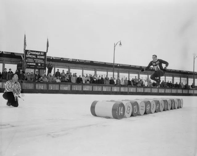 Terry Browne, 33-year-old Detroit, Mich., fireman, is at the halfway mark as he sails over 14 barrels, a distance of 27 feet, nine inches, to win the World Barrel Jumping Championship at Grossinger, N.Y., January 11, 1953. (Photo by AP Photo)