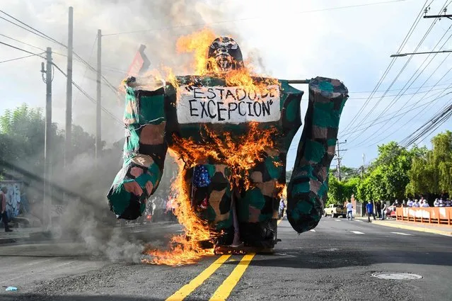 A burning gorrila with a sign reading “state of emergency” is seen during a demonstration commemorating the 47th anniversary of the massacre of university students on July 30, 1975 in San Salvador, on July 30, 2022. (Photo by Sthanly Estrada/AFP Photo)