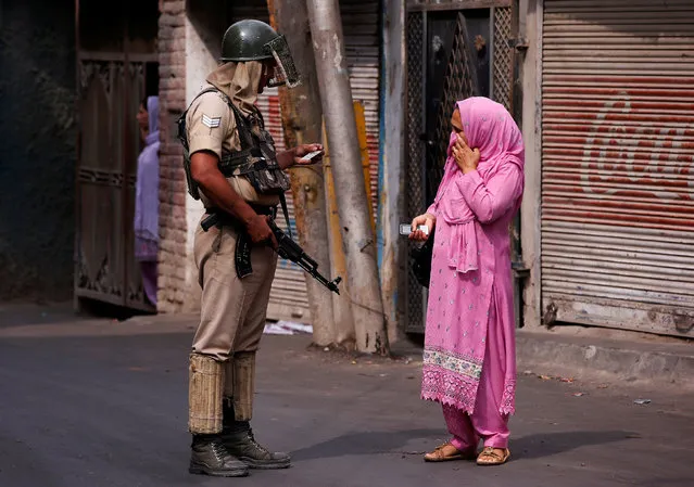An Indian policeman checks an identity card of a woman during a curfew in Srinagar July 14, 2016. (Photo by Danish Ismail/Reuters)