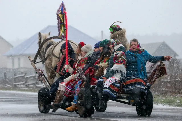 People in folk costumes ride in a horse drawn carriage to sing Christmas carols known as kolyadki in the village of Dubrovka in Brest Region, Belarus on January 7, 2020. Kolyadki is a Slavic Christmas tradition. Groups of people dressed in folk costumes come to houses to sing Christmas carols and receive treats from the hosts. (Photo by Natalia Fedosenko/TASS)