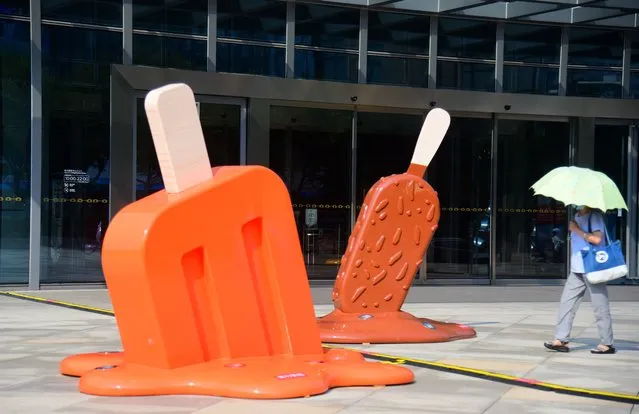 A citizen walks by popsicle-shaped installations outside a shopping mall amid a heat wave on August 2, 2022 in Hangzhou, Zhejiang Province of China. (Photo by Lian Guoqing/VCG via Getty Images)
