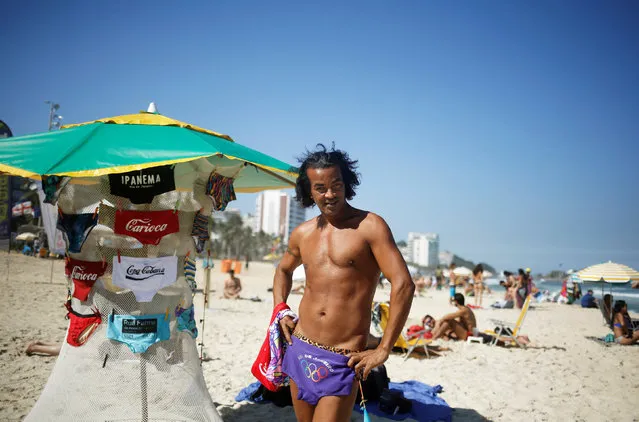 A beach vendor poses with a swimsuit on Ipanema beach in Rio de Janeiro, Brazil, May 3, 2016. (Photo by Nacho Doce/Reuters)
