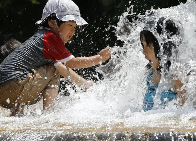 Children play in the water fountain at Asuka park in Tokyo, Monday, July 18, 2016. The temperature rose to 33 degrees Celsius (91 degrees Fahrenheit) in Tokyo on Monday. (Photo by Shizuo Kambayashi/AP Photo)