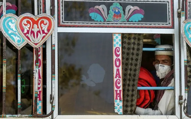A passenger wearing a facemask as a prevention measure against the COVID-19 coronavirus sits in a bus in Karachi on March 11, 2020. The number of novel coronavirus cases globally stood at 118,554, with 4,281 deaths, across 110 countries and territories by 0900 GMT on March 11, according to a tally compiled by AFP from official sources. (Photo by Asif Hassan/AFP Photo)