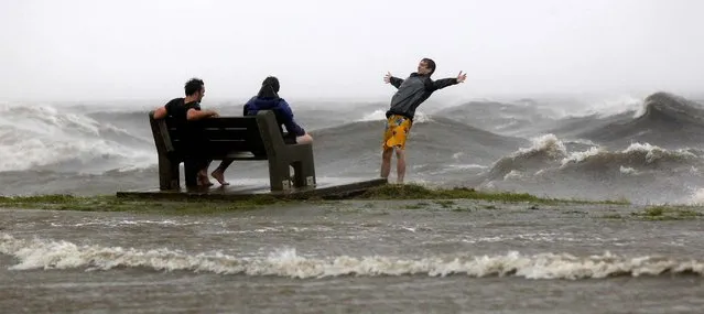 People play in the storm surge from Hurricane Isaac, on Lakeshore Drive along Lake Pontchartrain in New Orleans, as the storm neared land, August 28, 2012. (Photo by Gerald Herbert/Associated Press)