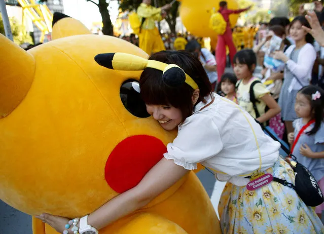 A woman hugs a performer wearing Pokemon's character Pikachu during a parade in Yokohama, Japan, August 7, 2016. (Photo by Kim Kyung-Hoon/Reuters)