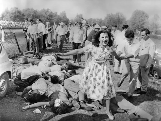 A woman under shock walks away from dead bodies following the accident caused by German driver Wolfgang von Trips, whose Ferrari crashed into the crowd killing 15 spectators during the Italian Formula One Grand Prix on September 10, 1961 in Monza. Wolfgang von Trips, who was thrown out of his car, also died in one of the most tragic accidents in Formula One history. (Photo by AFP Photo/Stringer)