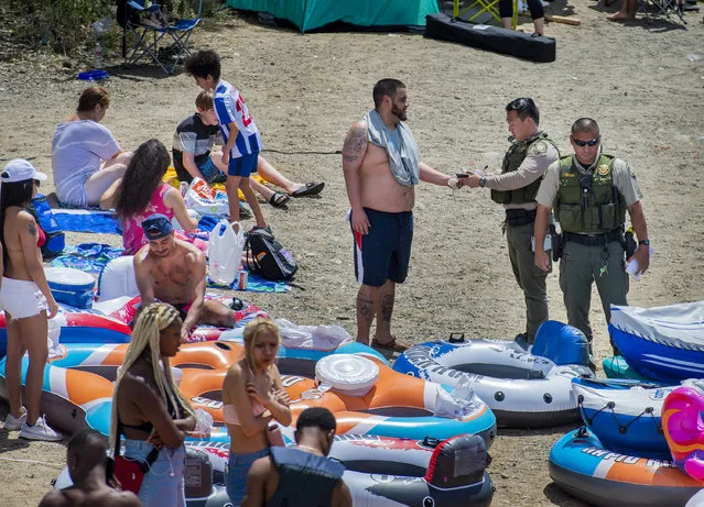 A Sacramento County park ranger issues an alcohol citation to an American River visitor in the Sunrise Recreation Area near Rancho Cordova, Calif., during the Memorial Day weekend, Sunday, May 24, 2020. Alcohol is banned along the shoreline of the river between Hazel and Watt avenues on Memorial Day weekend, the Fourth of July and Labor Day weekend. (Photo by Daniel Kim/The Sacramento Bee via AP Photo)