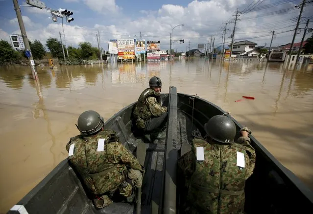Japanese Self-Defence Force's 1st Infantry Regiment soldiers are seen on a boat while conducting a search and rescue operation at a residential area flooded by the Kinugawa river, caused by Typhoon Etau at Araigi town in Joso, Ibaraki prefecture, Japan, September 12, 2015. (Photo by Issei Kato/Reuters)