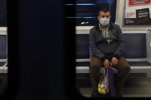 A man wearing facemasks for protective measures sits in the subway train as the spread of the COVID-19, the novel coronavirus continues in Ankara, on April 16, 2020. (Photo by Adem Altan/AFP Photo)