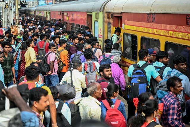 Passengers board a train to visit their respective hometowns ahead of the Hindu harvest festival of “Pongal”, in Chennai on January 12, 2024. (Photo by R. Satish Babu/AFP Photo)