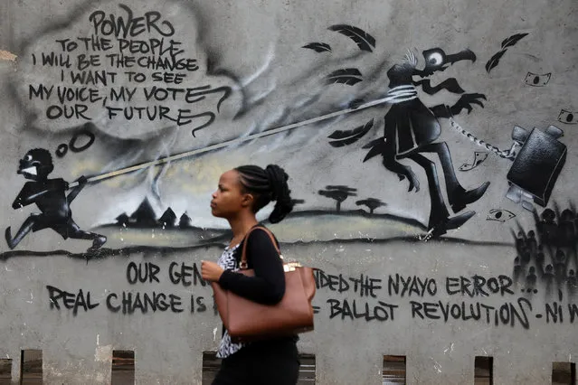 A woman walks past a wall of graffiti in the central business district in Nairobi, Kenya on October 23, 2017. (Photo by Siegfried Modola/Reuters)