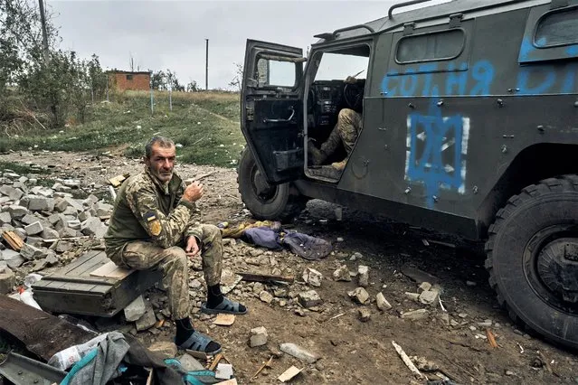 A Ukrainian soldier takes a break to rest in the freed territory in the Kharkiv region, Ukraine, Monday, September 12, 2022. Ukrainian troops retook a wide swath of territory from Russia on Monday, pushing all the way back to the northeastern border in some places, and claimed to have captured many Russian soldiers as part of a lightning advance that forced Moscow to make a hasty retreat. (Photo by Kostiantyn Liberov/AP Photo)