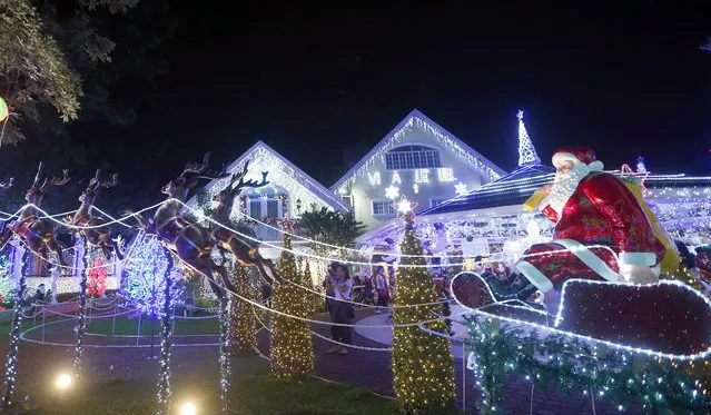 Filipinos take photos of the Christmas display at the decorated Villa Valenzuela known as “Santa Valenzuela” in suburban Cainta, Rizal province east of Manila, Philippines Tuesday, December 12, 2017. The whole compound is decorated with hundreds of thousands of LED lights as well as Santa Claus mannequins that also attracted local and foreign tourists. (Photo by Bullit Marquez/AP Photo)
