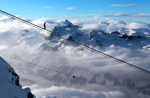High wire artist Freddy Nock walks on the rope of the Corvatsch cable car from the upper station, 10,837 feet over sea level, down to the base station in Silvaplana, Switzerland to set a new mark in the Guinness book of records. (Photo by Arno Balzarini/Keystone/Associated Press)