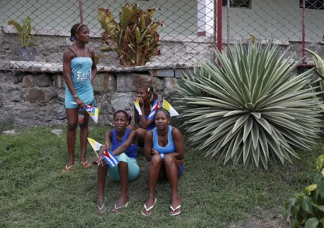 Women wait on the side of the road for Pope Francis to drive past in El Cobre, Cuba, September 21, 2015. Pope Francis said a Mass for tens of thousands of people in Holguin in sweltering heat before moving on to Santiago de Cuba, the city where Fidel Castro's rebellion began in 1953 and close to a shrine for the national patron saint, the Virgin of Charity. (Photo by Carlos Garcia Rawlins/Reuters)