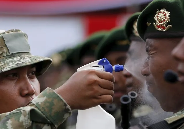 An Indonesian soldier sprays water onto the face of his colleague face before a rehearsal for a ceremony marking the 70th anniversary of Indonesia's military in Cilegon, Banten province, October 3, 2015. (Photo by Reuters/Beawiharta)