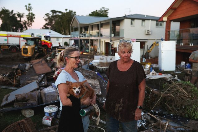 Sue Allport stands with a woman outside her home, which was hit by a flood, in Glenthorne, Australia on May 24, 2025. (Photo by Hollie Adams/Reuters)