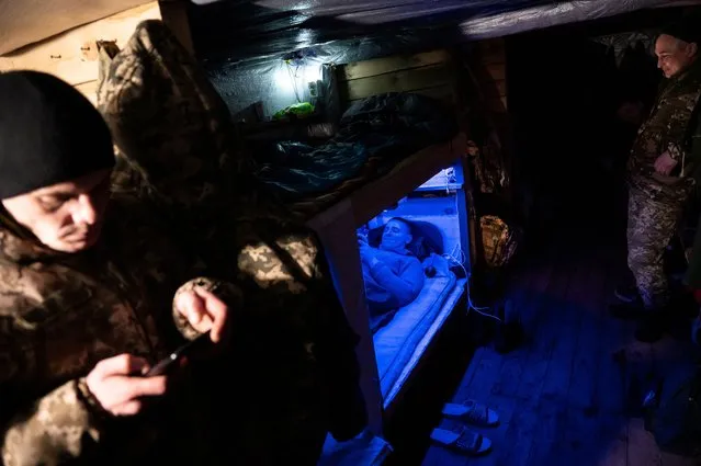 Ukrainian service members rest inside a dugout at a position near the border with Belarus, amid Russia's attack on Ukraine, in Zhytomyr region, Ukraine on December 27, 2022. (Photo by Viacheslav Ratynskyi/Reuters)