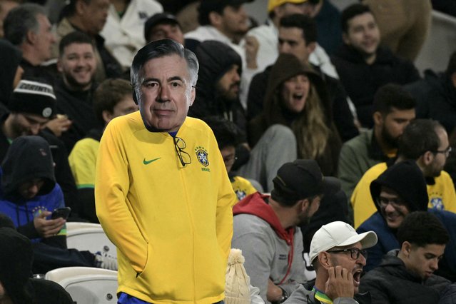 A fan of Brazil wears a mask of Italian head coach Carlo Ancelotti during the 2026 FIFA World Cup South American qualifiers football match between Brazil and Paraguay at the Neo Quimica Arena in Sao Paulo, Brazil, on June 10, 2025. (Photo by Nelson Almeida/AFP Photo)