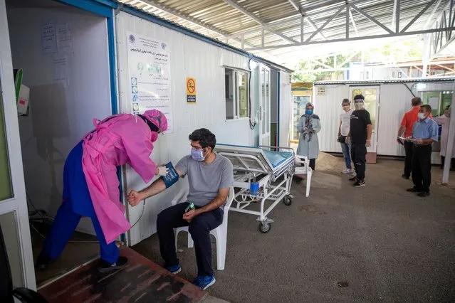 A medical staff member checks a man's blood pressure outside of Masih Daneshvari Hospital on August 19, 2020 in Tehran, Iran. Iran is experiencing a second wave of infections. After a dip in the middle of April the death toll has now reached over 100 people a day. Iran has been the country worst hit by the coronavirus in the Middle East. (Photo by Majid Saeedi/Getty Images)