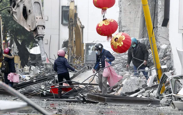 Survivors look for belongings during the demolition operation at a collapsed hotel building after a strong earthquake in Hualien County, eastern Taiwan, Friday, February 9, 2018. A magnitude 6.4 earthquake struck late Tuesday night caused several buildings to cave in and tilt dangerously. (Photo by Chiang Ying-ying/AP Photo)