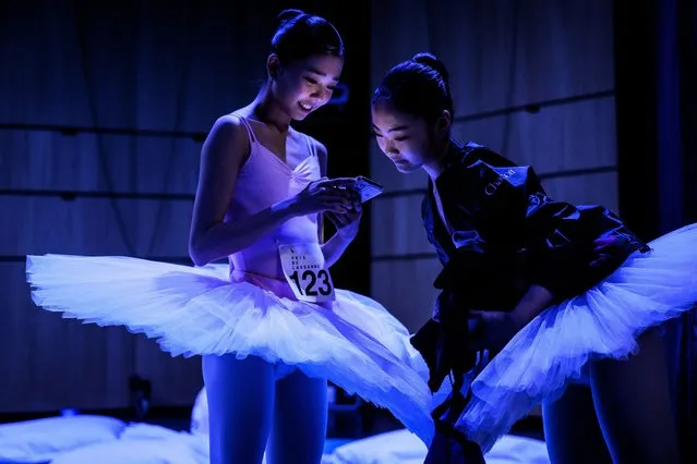 Yedam Kim (L) and Chaewon Kim, both of South Korea, look at a smartphone backstage after performing on stage during the first day of the 51st Prix de Lausanne at the Theatre de Beaulieu, in Lausanne, Switzerland, 30 January 2023. Launched in 1973, the Prix de Lausanne is an international dance competition for young dancers aged 15 to 18. Closing the six-day event, scholarships granting free tuition in a world-renowned dance school or dance company will be award to the best dancers out of 87 participants who come from 18 different countries this year. (Photo by Laurent Gillieron/EPA)