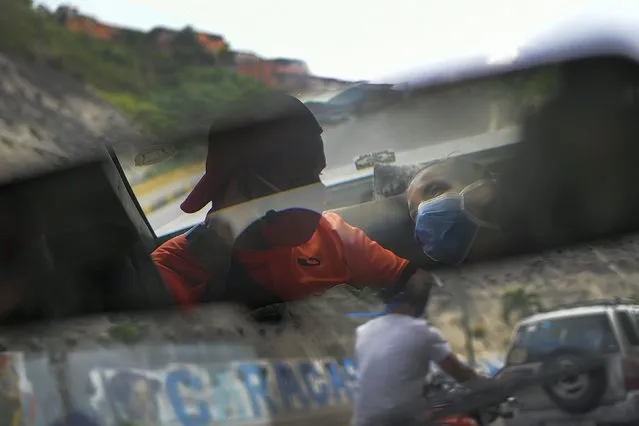 Reflected in the rearview mirror, Leo Camejo sits with his partner Ada Mendoza and their newborn baby daughter Peyton as a friend drives them home after being discharged from the hospital, in Caracas, Venezuela, Saturday, September 12, 2020. The young couple met three years ago thanks to their love of soccer, as fans of the Caracas F.C. team. (Photo by Matias Delacroix/AP Photo)