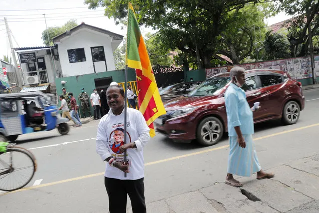 A supporter of Sri Lankan Prime Minister Mahinda Rajapaksa  waves a national flag outside Rajapaksa's residence in Tangalle, Sri Lanka, Friday, August 7, 2020. The country's powerful Rajapaksa brothers secured a landslide victory in the parliamentary election, giving them nearly the two-thirds majority of seats required to make constitutional changes, according to results released Friday. Rajapaksa is likely to be sworn in the same position by his younger brother, President Gotabaya Rajapaksa, after the vote that could strengthen dynastic rule in the Indian Ocean island nation. (Photo by Eranga Jayawardena/AP Photo)