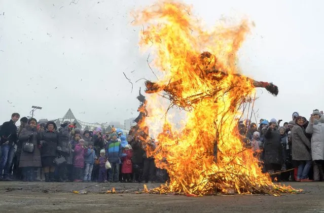 People burn an effigy of Lady Maslenitsa as they celebrate Maslenitsa, or Pancake Week, in the Russian far eastern city of Vladivostok, March 17, 2013. Maslenitsa is widely viewed as a pagan holiday marking the end of winter and is celebrated with pancake eating, while the Orthodox Church considers it as the week of feasting before Lent. (Photo by Yuri Maltsev/Reuters)